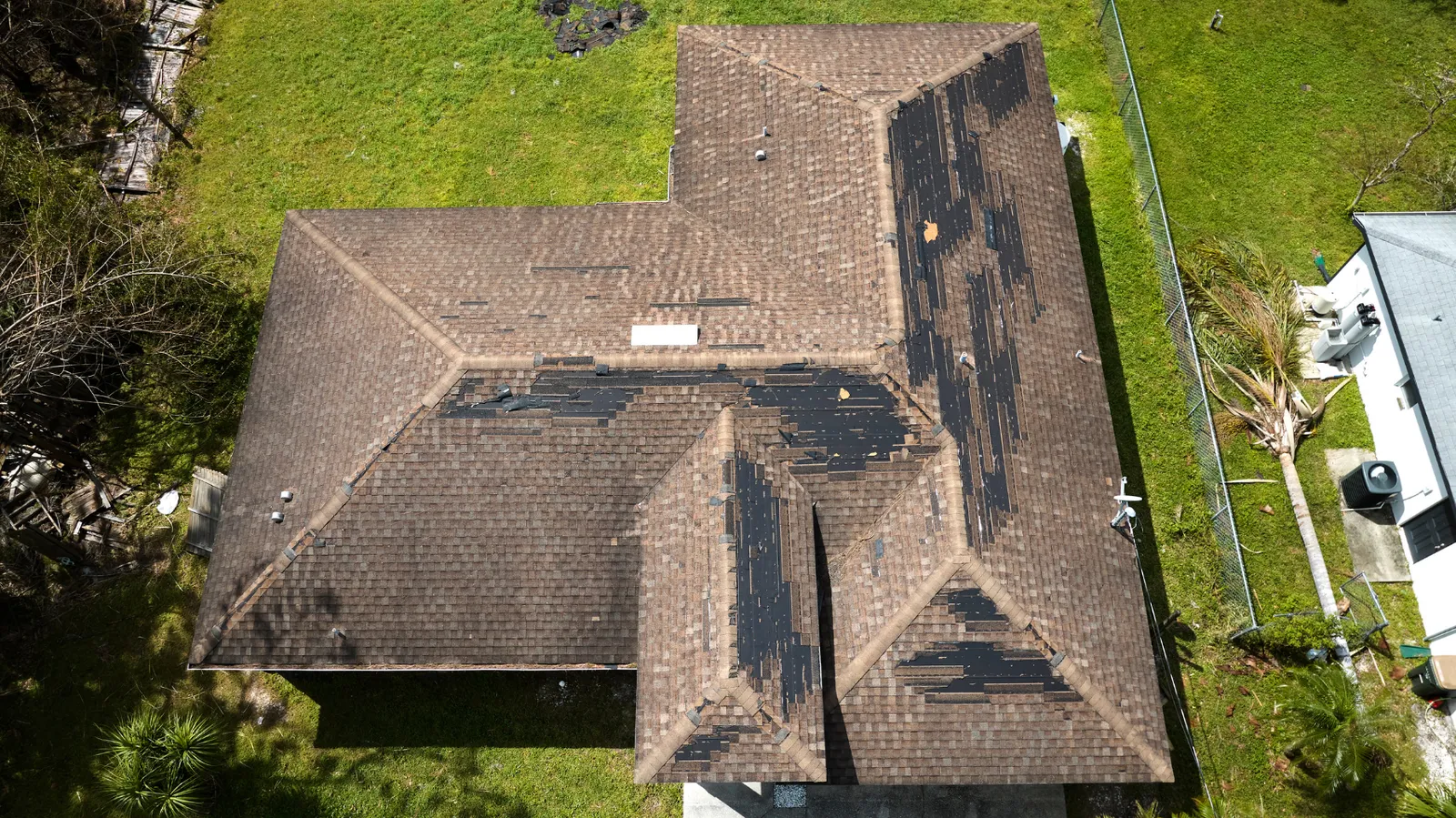 Roof with many shingles torn away seen from the air